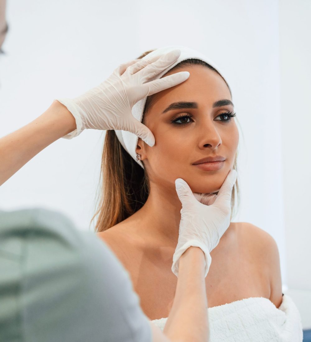 Checking final results. Woman face getting facial care by beautician at spa salon.