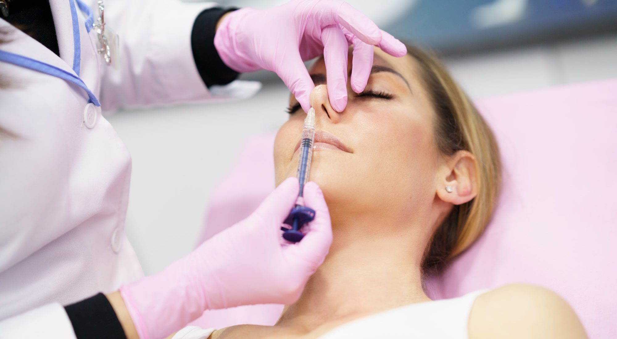 doctor-performing-rhinoplasty-by-injection-of-hyaluronic-acid-in-the-nose-of-his-patient-1.jpg